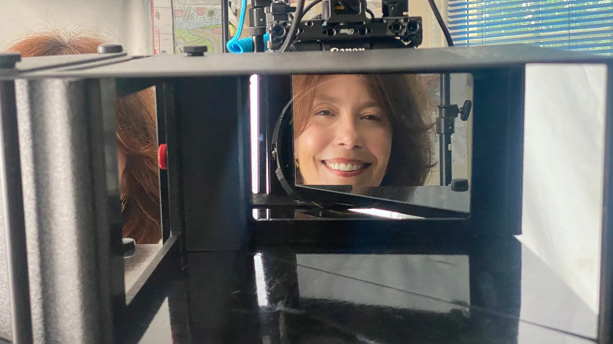 Steffi Ockenfels smiles from the EyeDirect mirror in front of the camera lens, as the person being interviewed sees her.