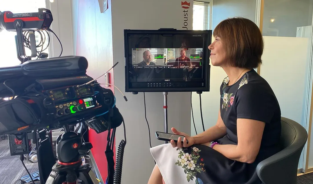 Steffi Ockenfels interviews Geekdom CEO Charles Woodin, who appears on the monitor beside the sound recorder.