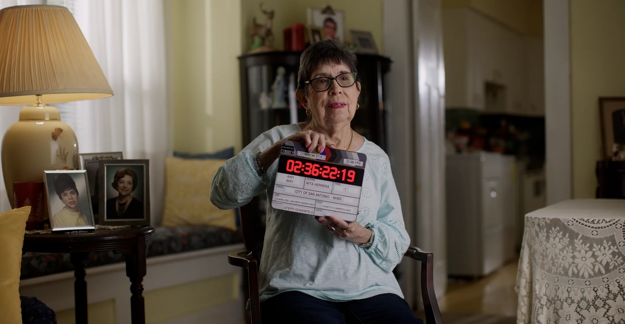 La Sra. Herrera sostiene la claqueta en la sala de su casa, antes de la entrevista.