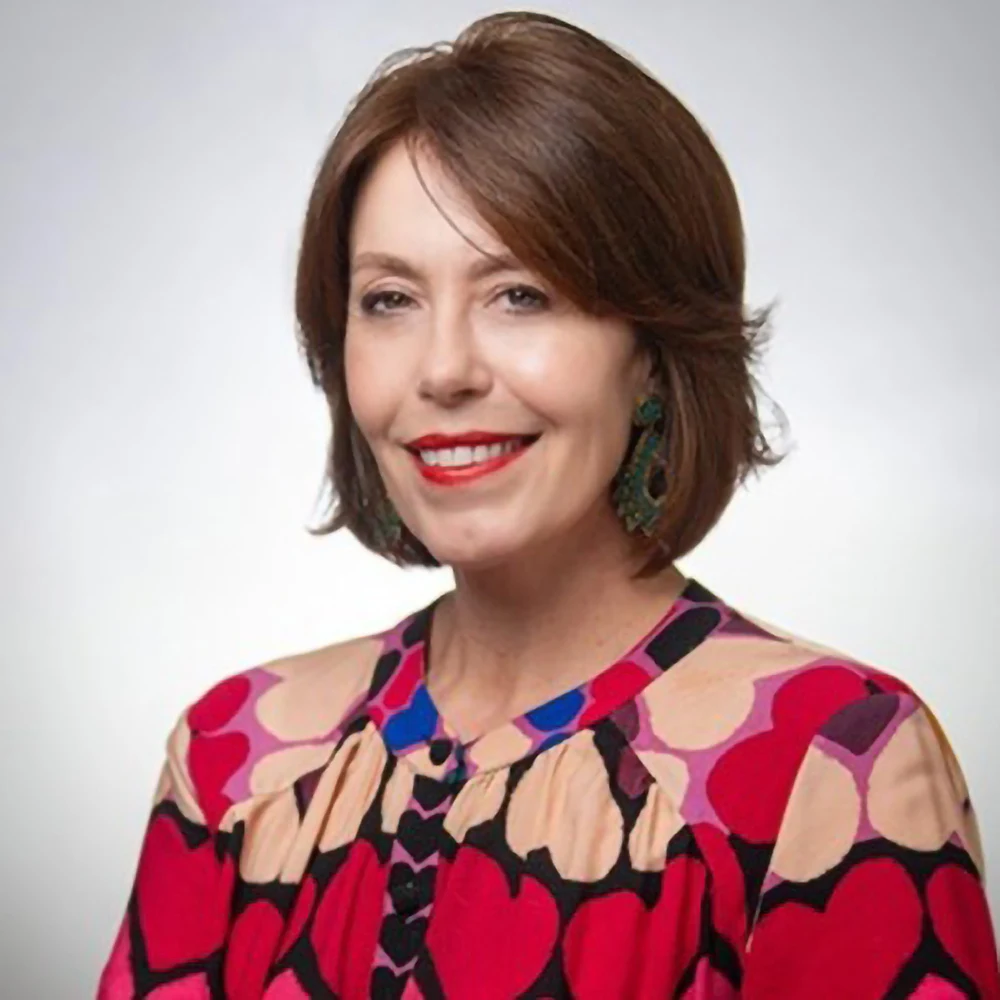 Steffi Ockenfels, CEO and executive producer of pixelreflex MEDIA, smiling in a red patterned blouse.