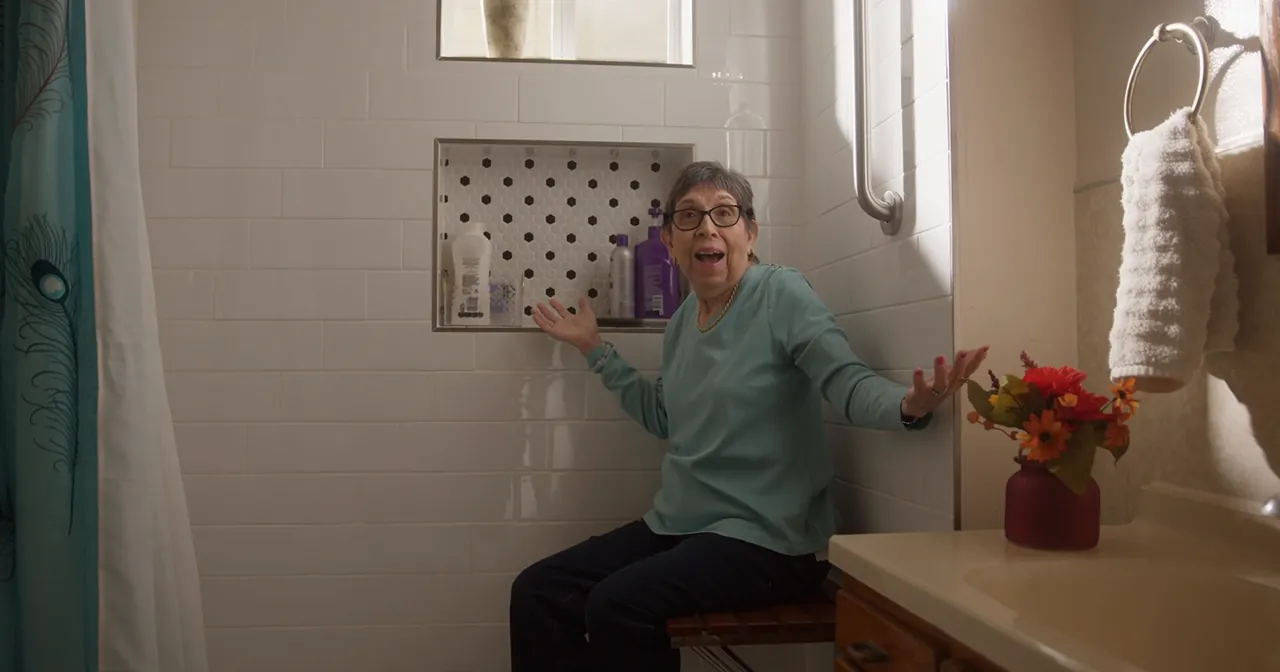 Ms. Herrera laughs as she shows her renovated bathroom.