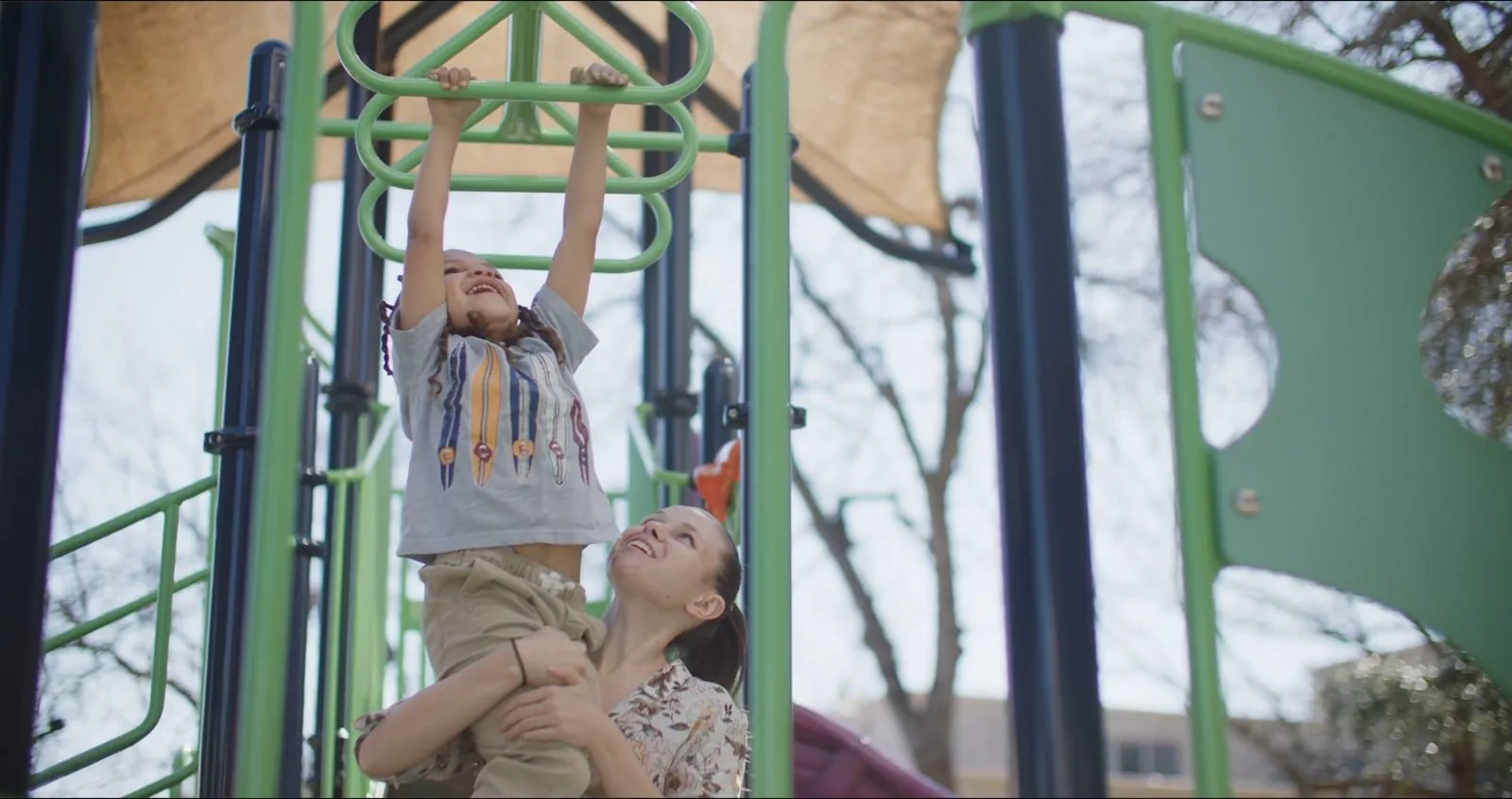 Ashley Keen helps a child swing from playground monkey bars in her SAMMinistries story.