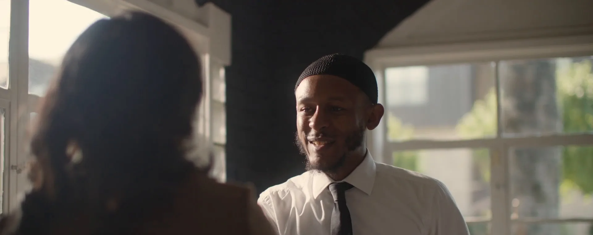 NPower alum Tahjee Speight smiles during a meeting in a sunlit office.
