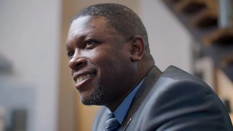 NPower alum Raymond Robinson, Jr., in a suit and tie, smiles during his interview.