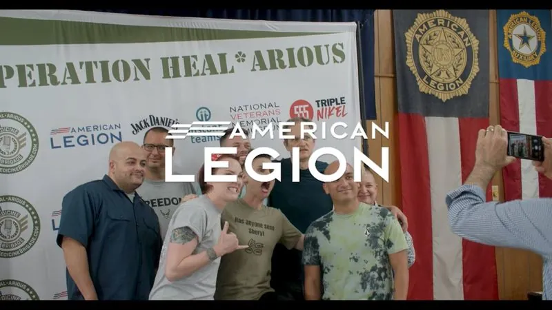 Veterans pose in front of an Operation Heal*arious backdrop at the American Legion Alamo Post 2 comedy show.