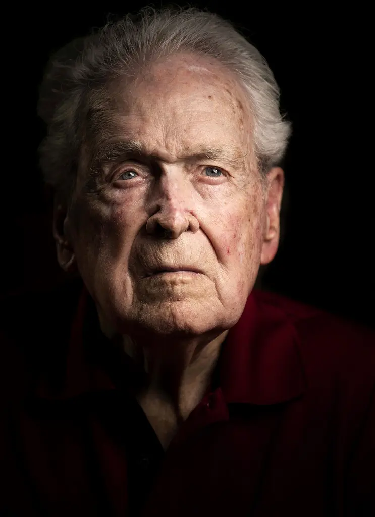 Reid Clanton, an elderly World War II veteran with white hair, in a dramatic portrait on black