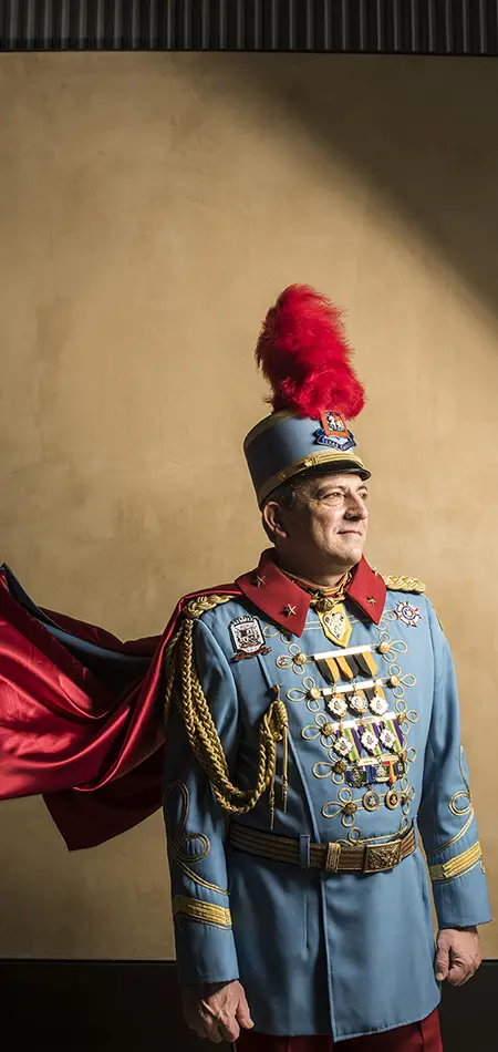Dr. Michael A. Casillas as King Antonio XCV in a blue ceremonial uniform, red-plumed helmet and red cape