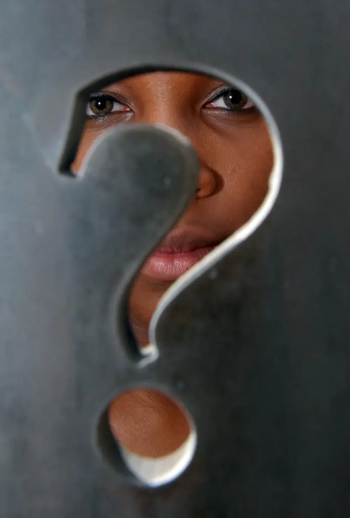 Caterina Rodriguez's eyes and lips seen through a question mark cut into a dark panel