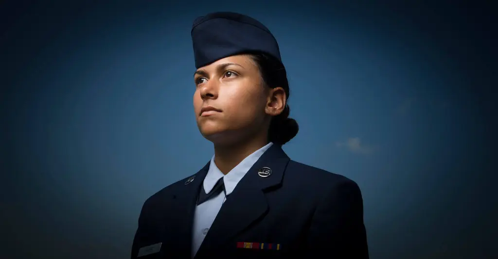 Young woman in Air Force service dress and flight cap gazing into the distance against a deep blue sky