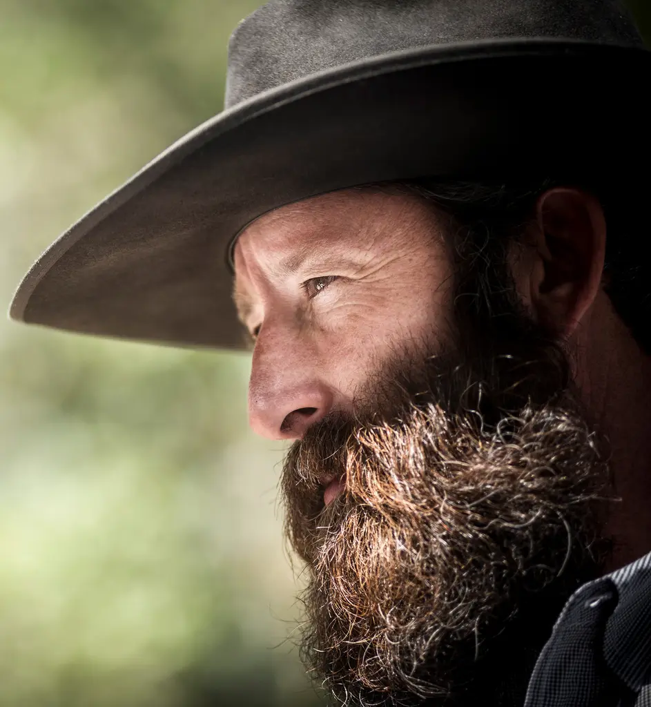 Close profile of Brian Gilroy in a black cowboy hat with a long, full beard