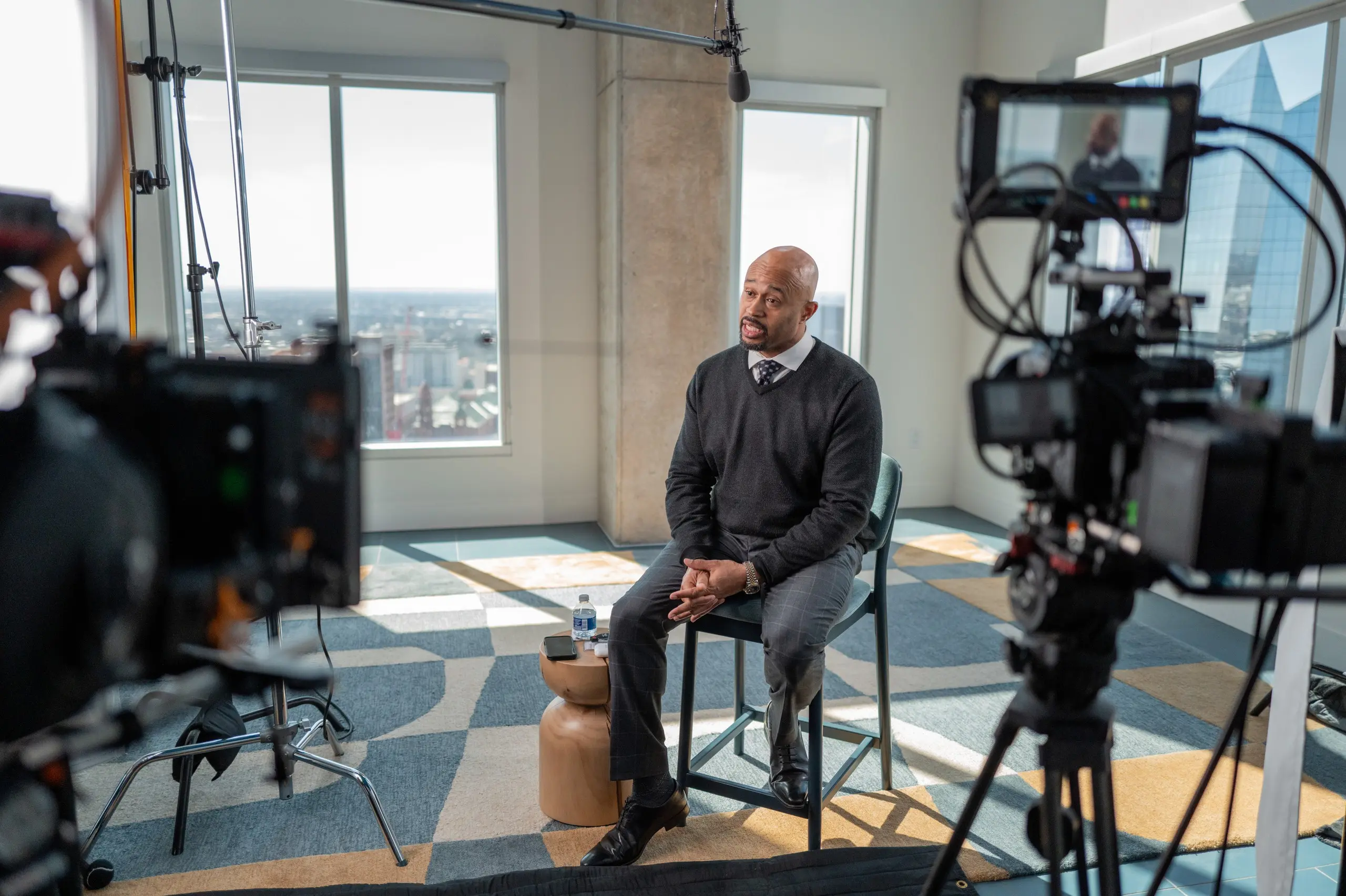 Mike Ramsey of City of San Antonio Workforce Development answers a question on a high-rise interview set while the monitor on a second camera shows his shot.