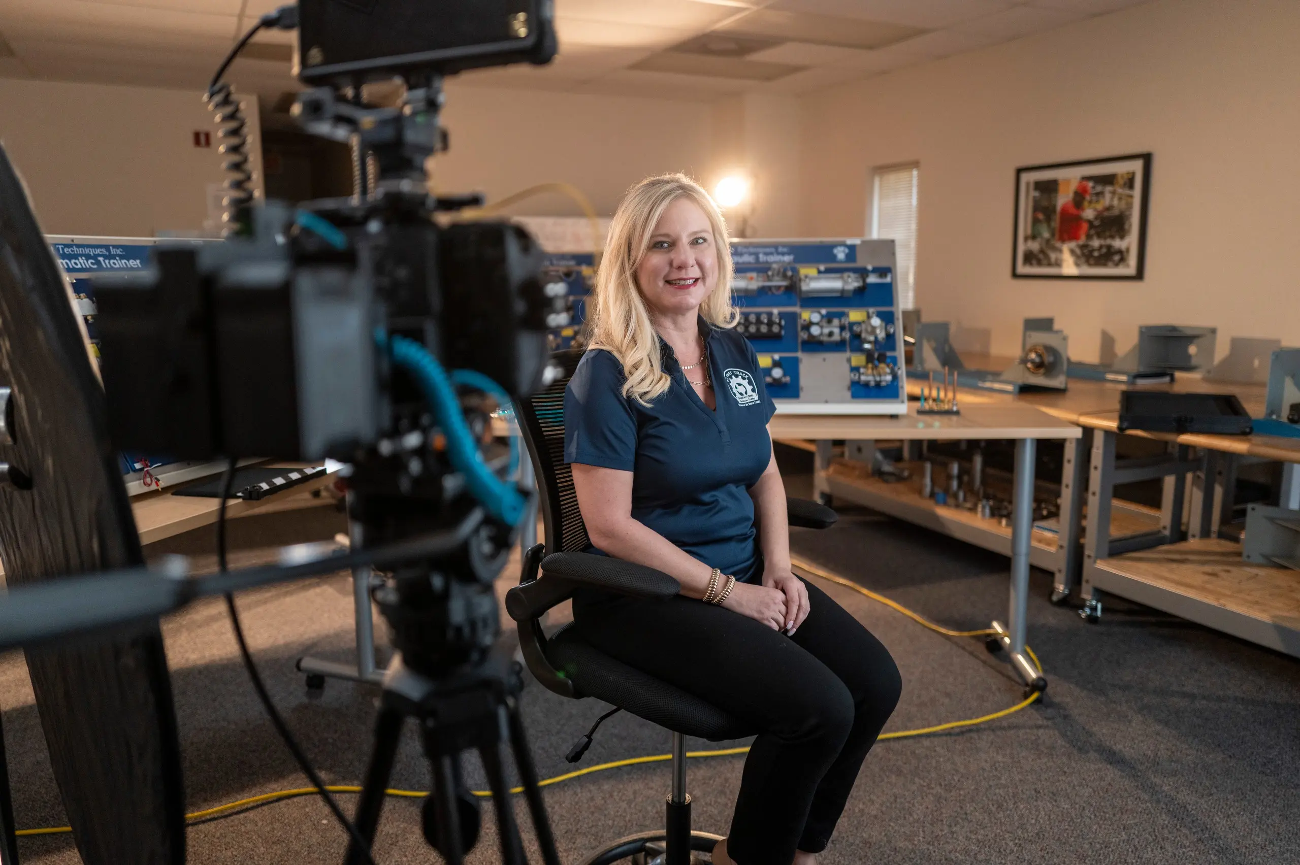 Deborah Carter of Bexar County smiles for a portrait on the set of her TX Fast Track Program interview, with a cinema camera in the foreground.